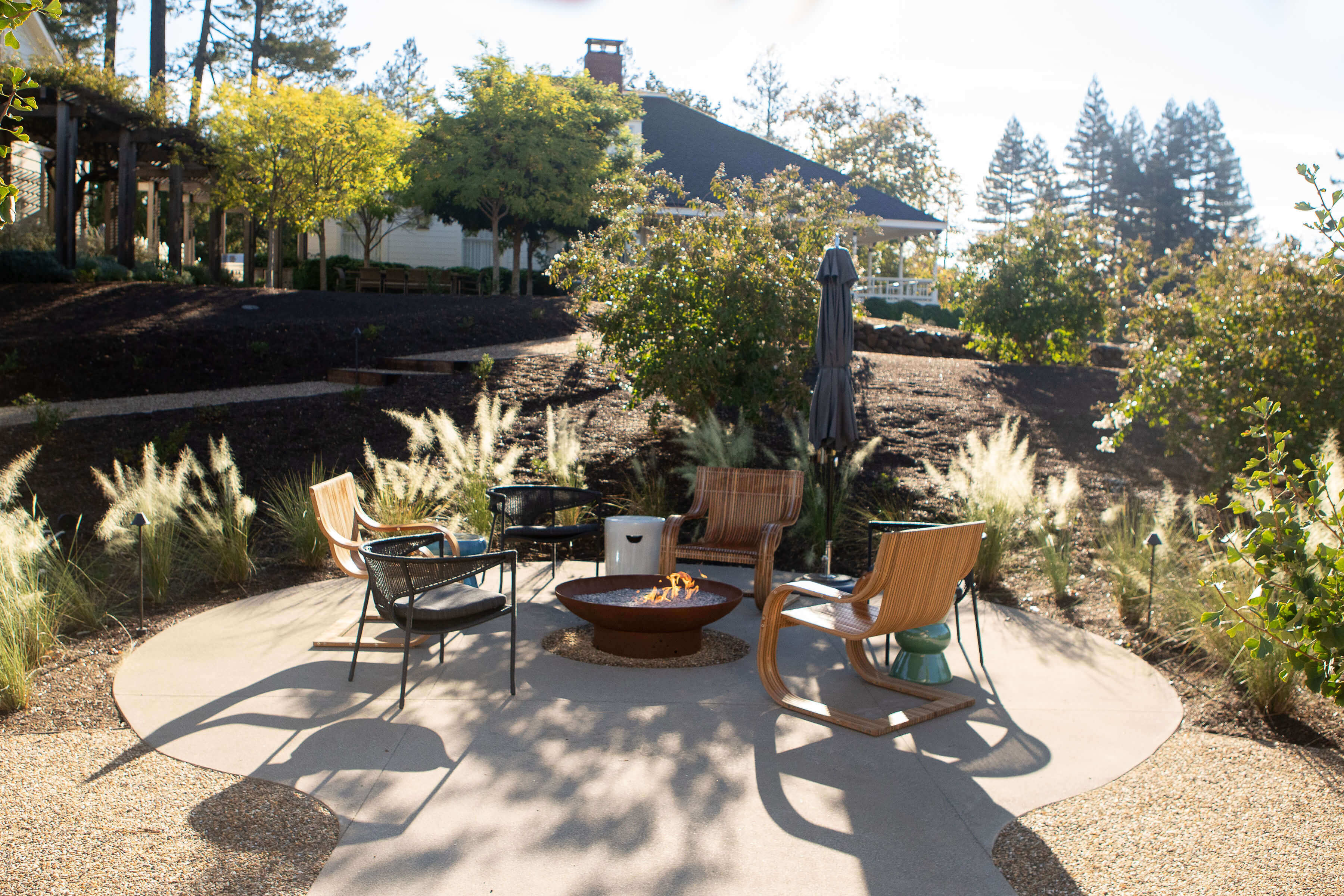 Outdoor Seating Area with Fire Pit Surrounded by Lush Landscape